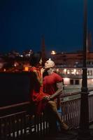 chico y chica abrazándose en un fondo del puerto nocturno foto