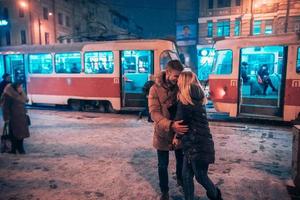 Young adult couple on snow covered tram station photo