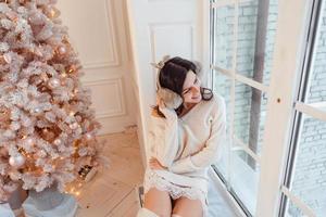 Young woman in an elegant dress near the Christmas tree photo