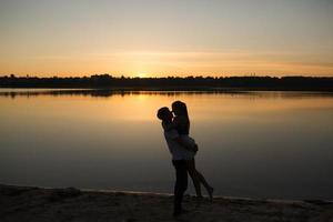 Couple in sunrise on the beach photo