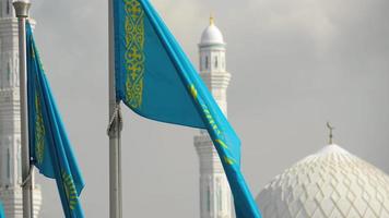 banderas de la república de kazajstán en la cúpula de fondo y torres de la mezquita. video