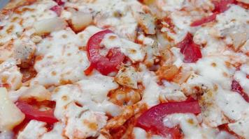 la superficie de una pizza con queso derretido y tomates. video