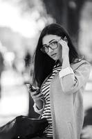 model in the middle of the city with phone photo