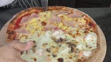 pizza italiana cozida em forno a quente. depois disso cortado por faca circular video