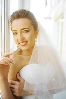 Young beautiful bride posing against the window photo