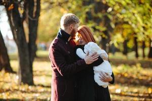 young family and newborn son in autumn park photo