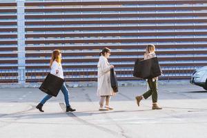 mujeres jóvenes con bolsas de compras caminando por la calle. foto