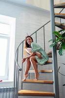 Young woman on wooden stairs in modern house. photo