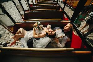 Bride and groom posing in a tour car photo