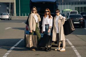 Young women at the car with shopping bags photo