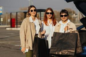 mujeres jóvenes en el auto con bolsas de compras foto