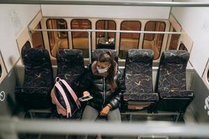 Young woman with mask traveling in the public transport. photo