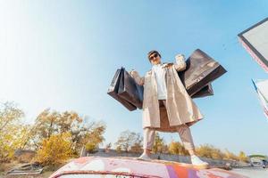 A young woman is standing in a car with bags in her hands photo