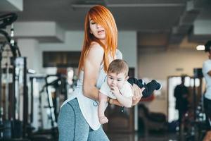 joven madre con su hijo pequeño en el gimnasio foto