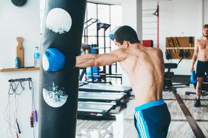 boxeador con saco de boxeo en el gimnasio foto