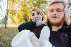 young family and newborn son in autumn park photo