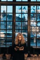 Woman reading a book on the background of window photo