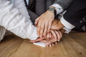 United hands of business team on workspace background photo