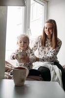 Mom and daughter drink something with mug photo