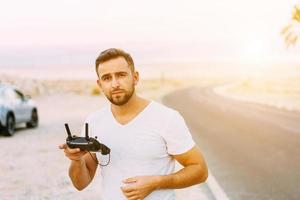 Guy controls drone with remote control photo