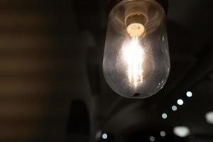 Glowing vintage light bulb from close perspective in the dark photo