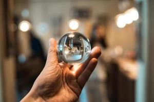 man holding a glass ball indoors photo