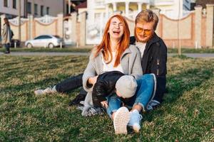 happy mom dad and son hugging in the park photo