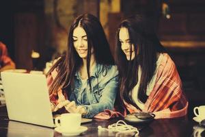 dos chicas viendo algo en la computadora portátil foto