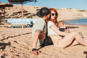 Parents spend time with their son on the beach photo