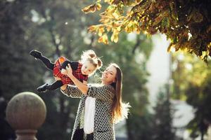 Mother and little daughter playing in a park photo