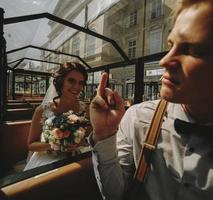 Bride and groom posing in a tour car photo