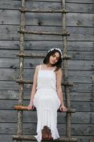 Lovely girl near a wooden house photo