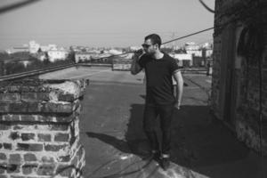 The man in the authentic boots and jeans selvedge on the roof of the building in the old town photo