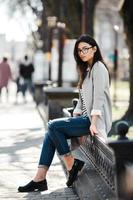 Beautiful model in glasses sit on the fence photo