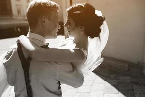 groom carries bride in his arms photo