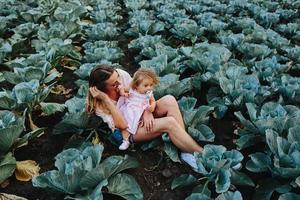 madre e hija en el campo con repollo foto