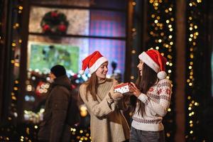 The girl gives a gift to her female friend on the street. photo