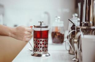 fresh berry tea in French press on the table photo