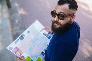 bearded man with a map in hand photo