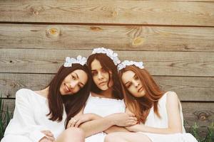 Three charming girls  near a wooden house photo