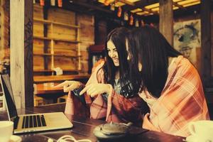 dos chicas viendo algo en la computadora portátil foto