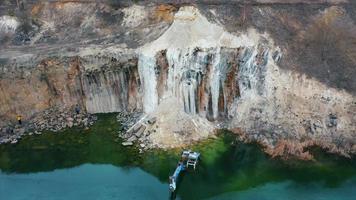 Flooded excavator in a large lake near the basaltic quarry photo