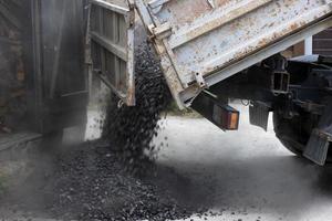 A truck unloads black coal on the street. Soft focus. photo