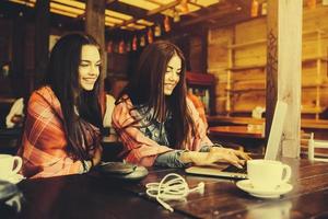 dos chicas viendo algo en la computadora portátil foto