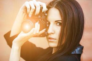 Beautiful female photographer posing with camera photo