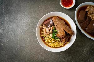 fideos de huevo con pato guisado y estofado en sopa marrón foto