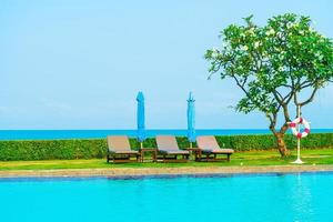 chair pool  or bed pool and umbrella around swimming pool with sea background photo