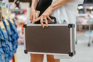 The girl holds a small aluminum case photo