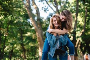 hermosas mujeres divirtiéndose en el parque. amigos y concepto de verano. foto