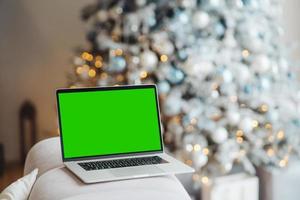 laptop with green screen - chromakey near New Year's decorations. christmas theme. photo